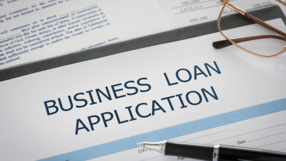 A business loan application form with a pen and eyeglasses